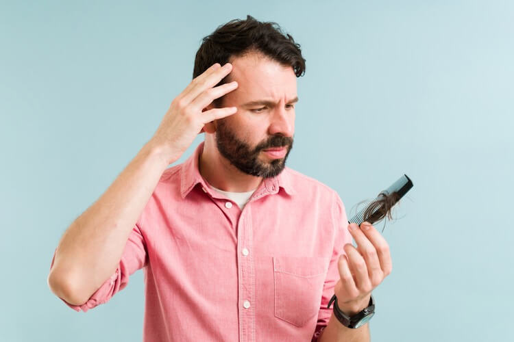 Guy losing his hair because of stress and thinking about a solution to regrow his hair. Happy Head's dermatologists can help you get your hair back with custom-made topical treatments. Our topical treatments are prescription and made for you. 